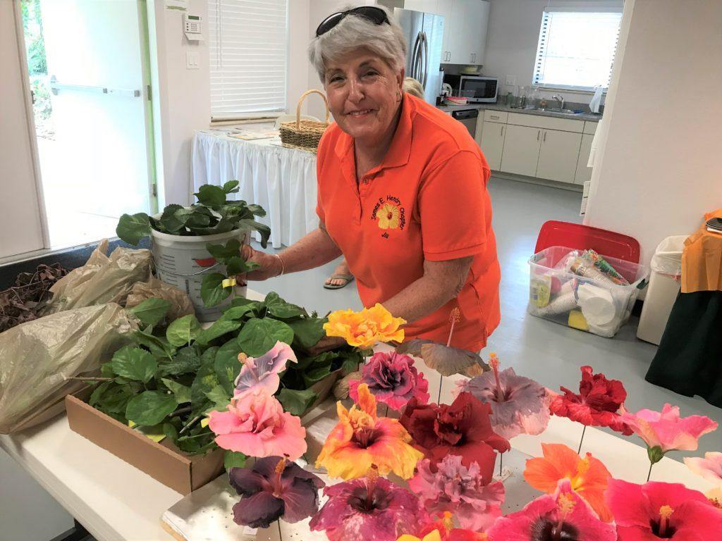 Woman arranging colorful flowers indoors.