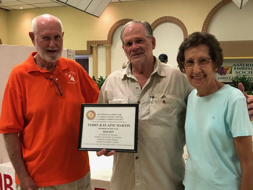 Smiling elderly man in casual beige shirt indoors.