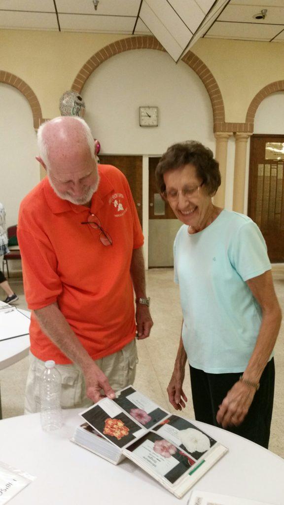 Two men smiling and standing together indoors.